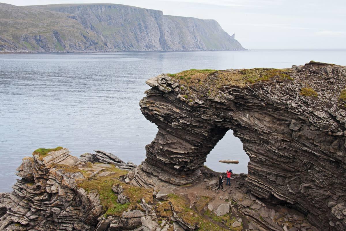 Nordkappin kalliojyrkänne ja kohti taivaita sojottava Nord Cape Horn kurkottavat pohjoiseen taivaanrantaa, näkymä kaakosta Kirkeportenilta Mefjordenin vastarannalta