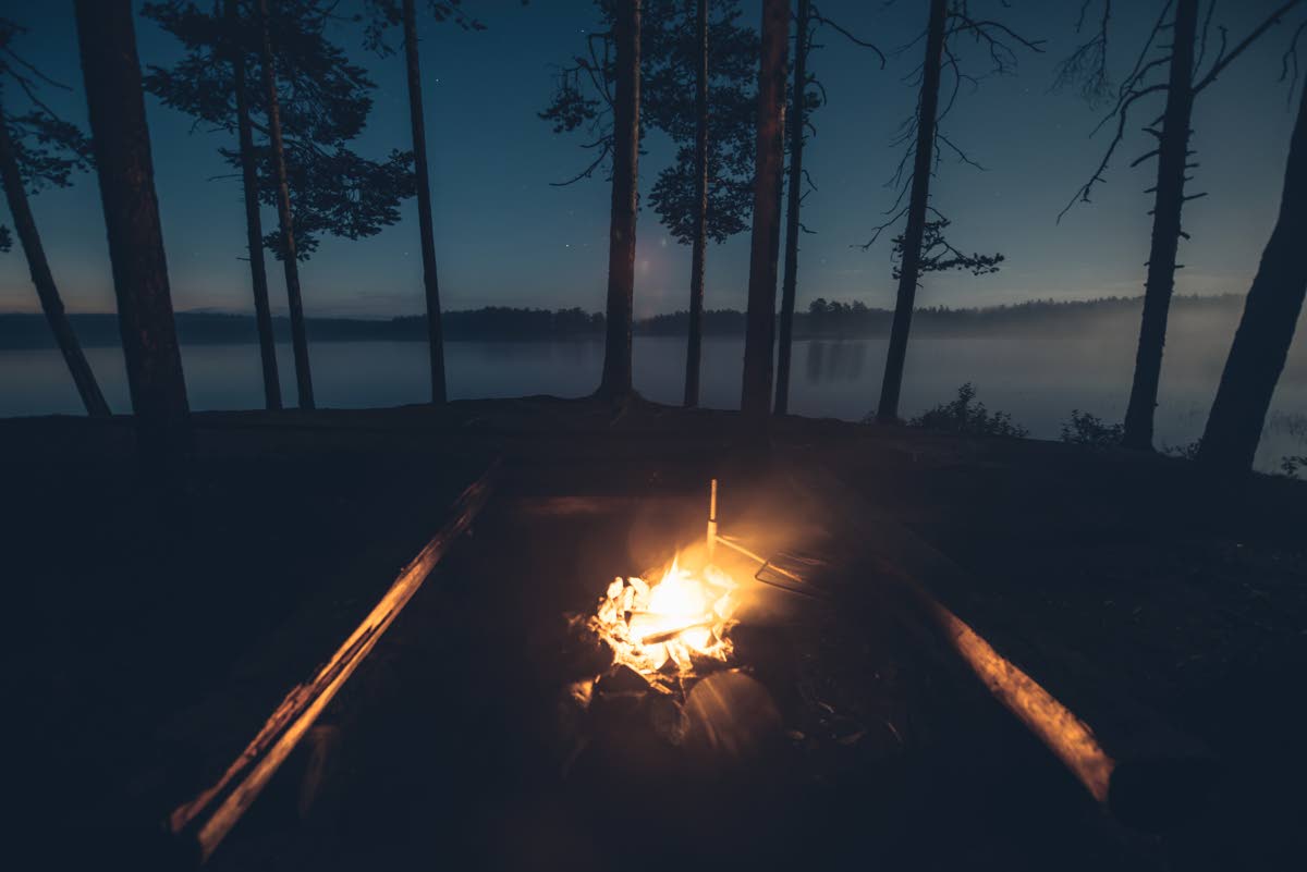 Iltanuotio valaisee Kokalmuksen järvimaisemaa kilpaa kuun kanssa.