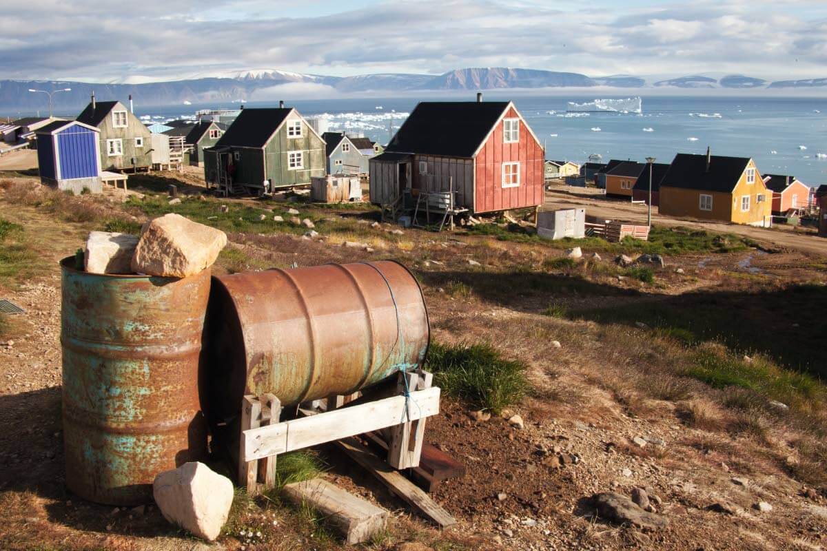 Iloisen värikkäät teräväharjaiset talot rytmittävät polaarieskimoiden karun pääkaupungin Qaanaaqin katukuvaa
