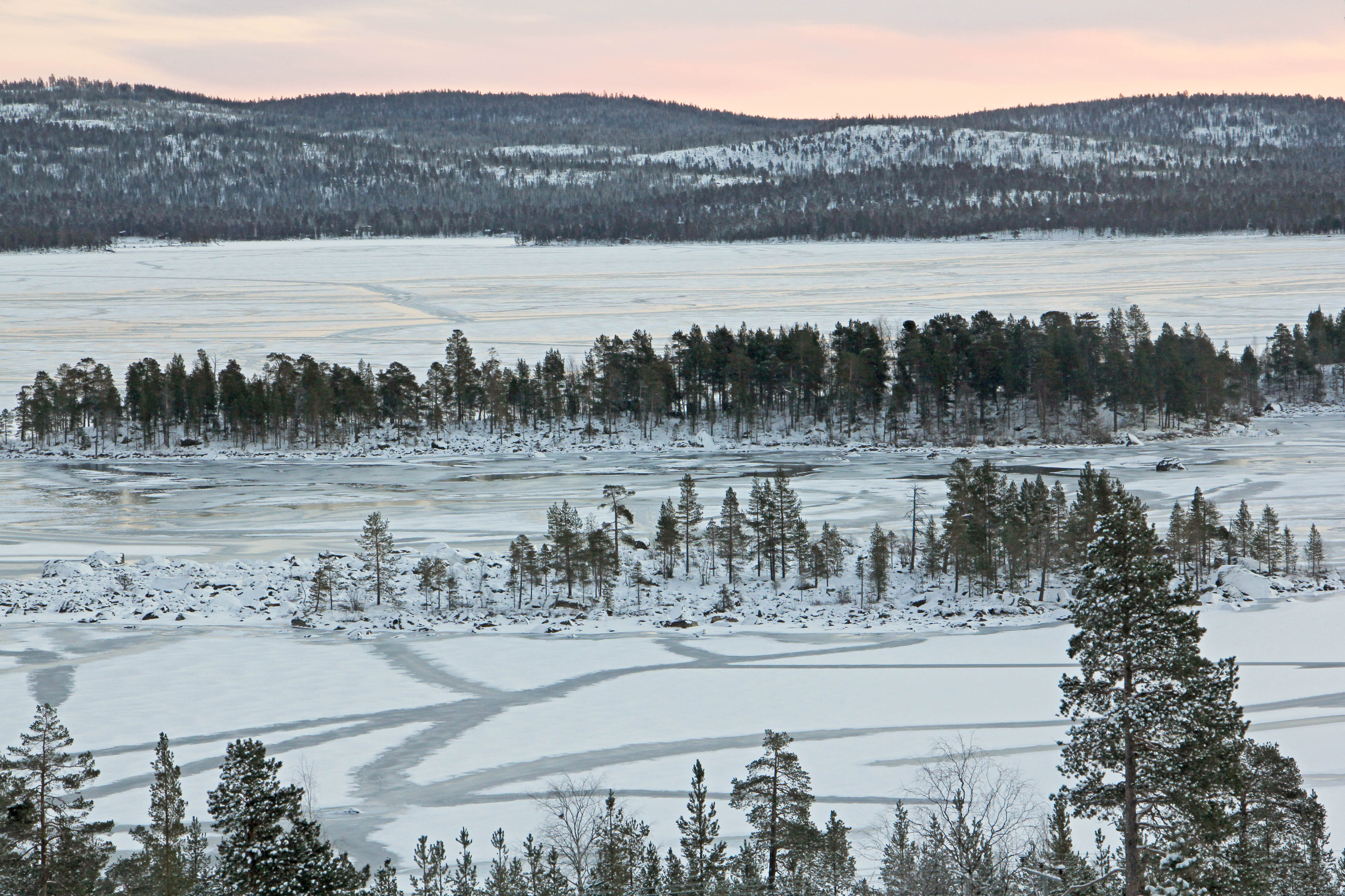 Talven ensimmäinen kunnon pakkasyö muodostaa kymmeniä railoja juuri jäätyneen Ukonjärven saaristoon, kaamosmaiseman keskelle. Kuva: Matti Mela.