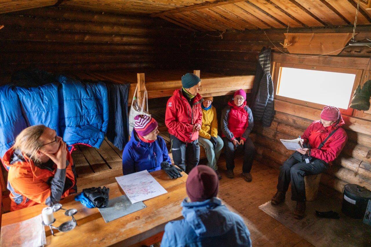 Päivän ohjelman läpikäyntiä tuvan suojissa.