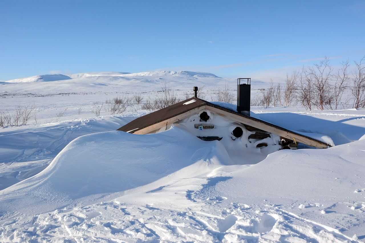 Lumeen hautautunut Porojärven kämppä sai pari kertaa nielaisemaan, ja sitten tarttumaan lapioon. Kuva: Raija Hentman.