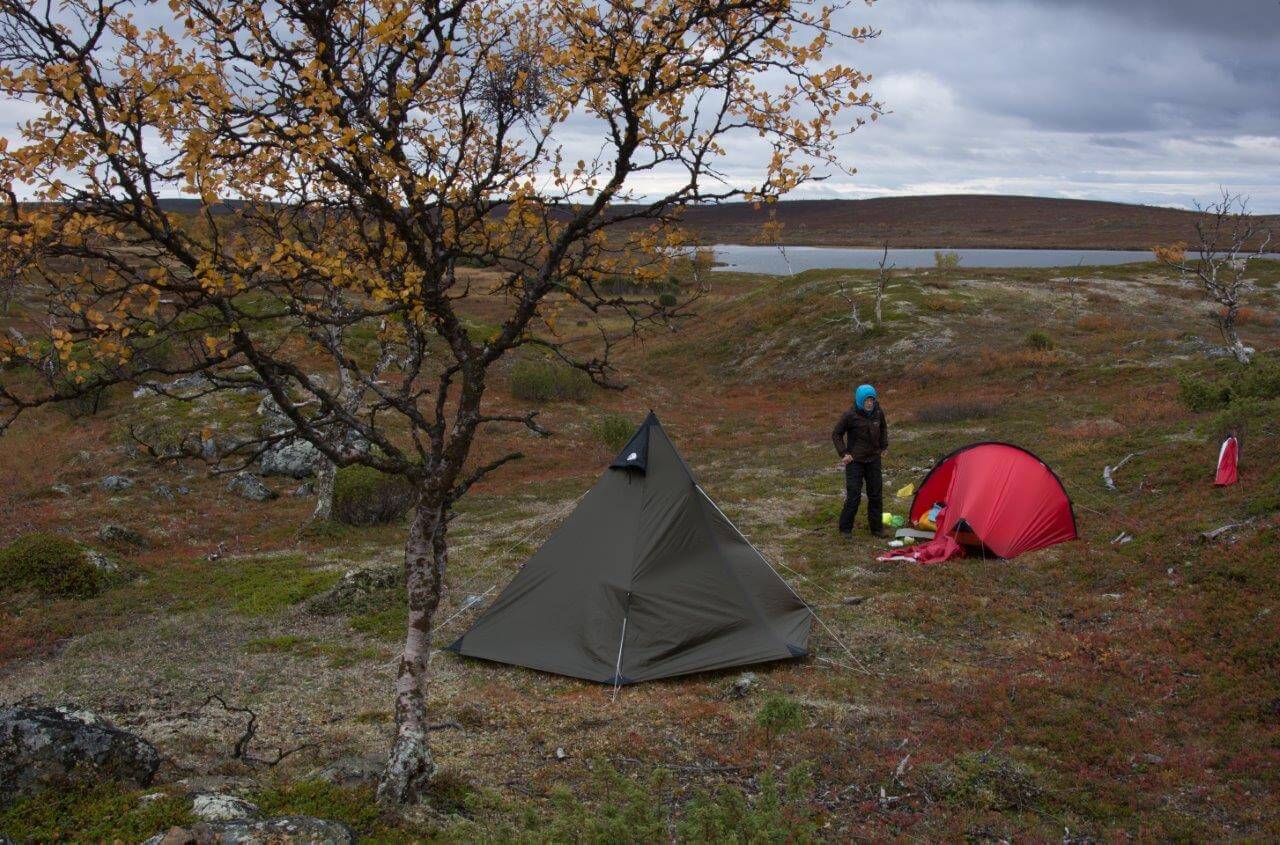 Aittajärven leiripaikka harjun kainalossa.