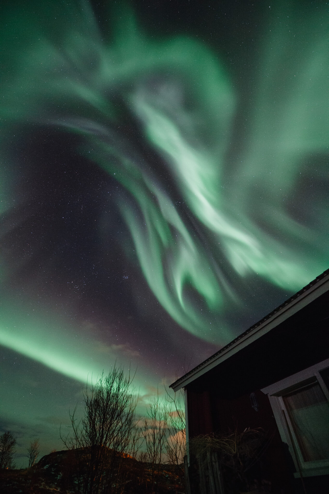 Pieni punainen tupa, taustalla maailmankaikkeus.