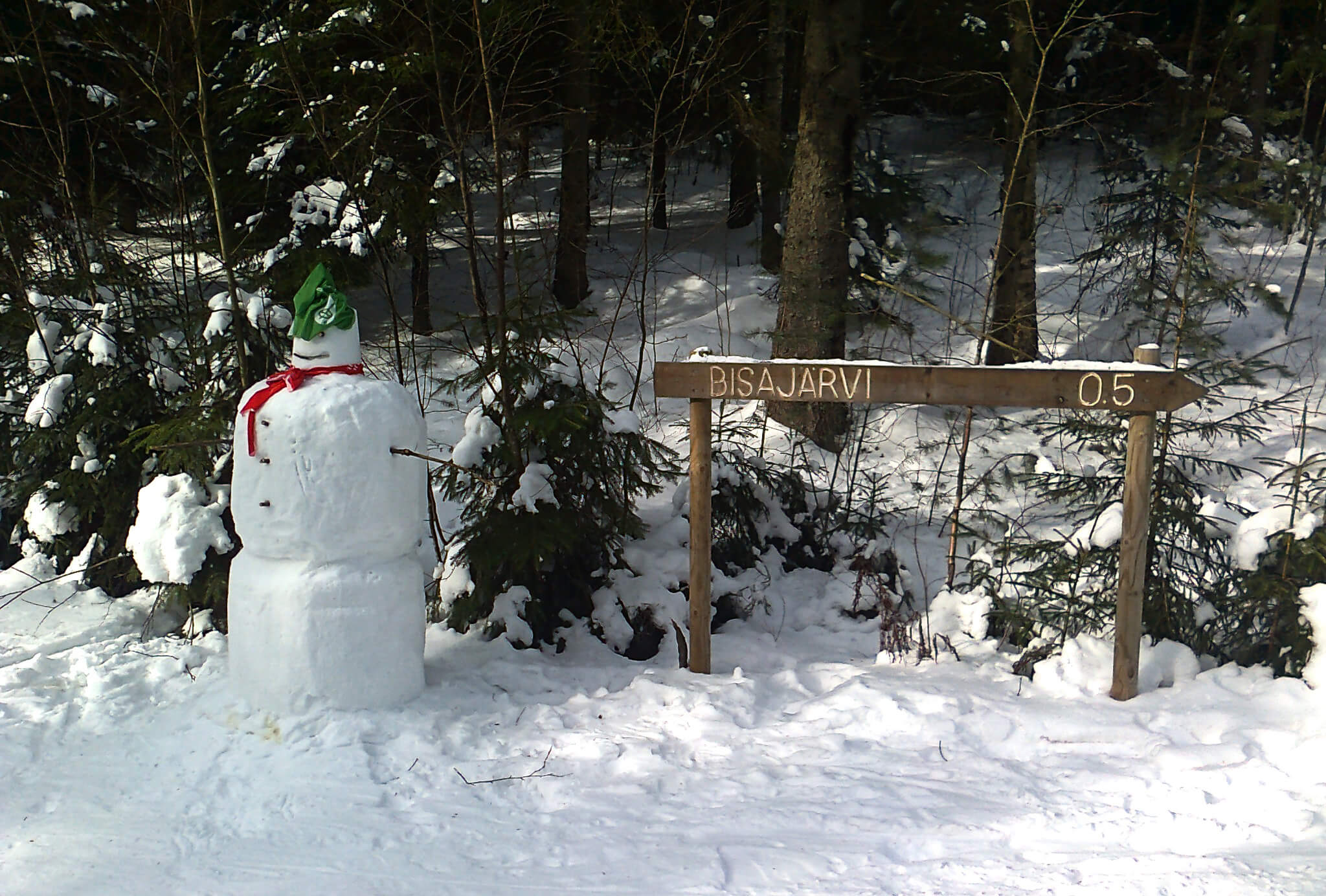 Lumiukko tervehtii Vantaan Ladun Bisan majalle menijää.