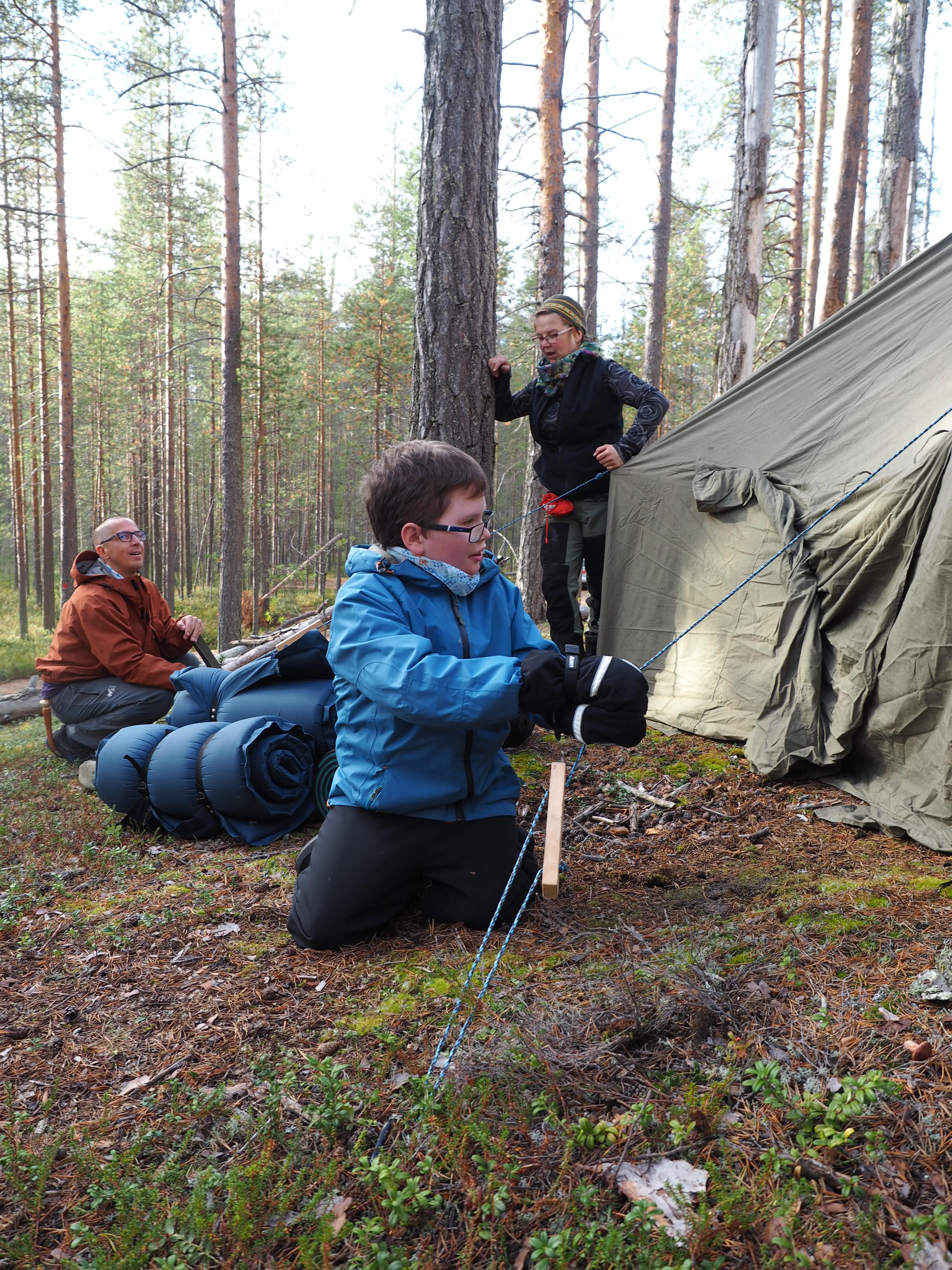 Aarni Tähtinen pystyttää telttaa Kimmo Kolehmaisen ja Tuija Laurosen kanssa. Kuva: Malike.