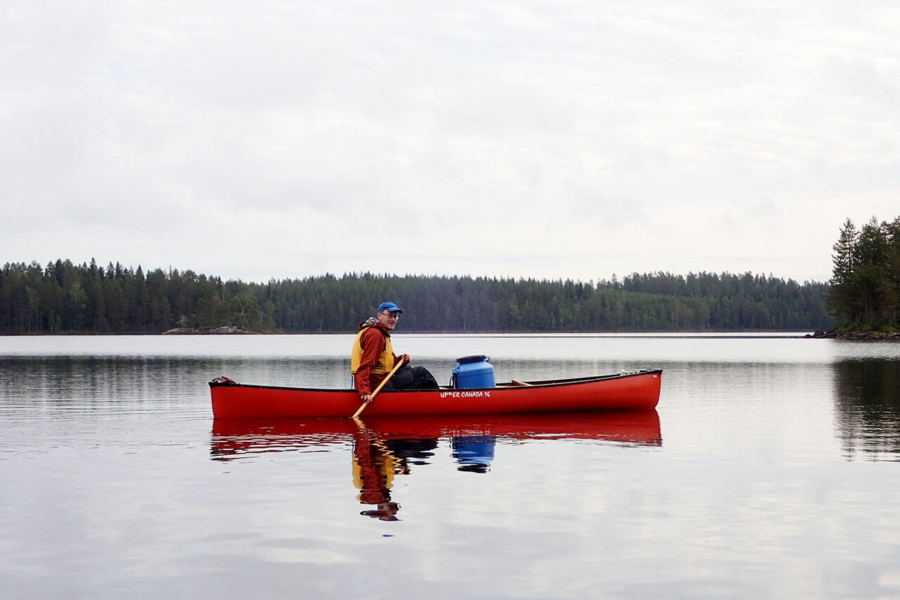 Kanootinsiirto niemen toiselle kyljelle aamun aluksi Mujejärvellä. Kuva: Jouni Laaksonen.