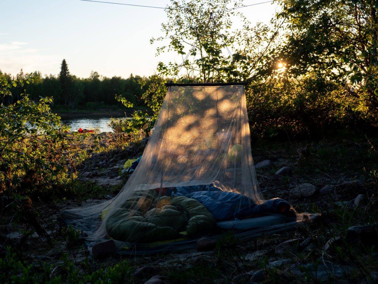 Juhannusaattona laskimme ilta-auringossa vielä yhden kosken, ja onneksi laskimme, sillä koski päättyi suoraan pienelle asumattomalle saarelle. Ohjasimme lauttamme ja kajakkimme suoraan koskesta rantaan ja leiriydyimme hienolle kivikkorannalle. Päätimme kokeilla majoitteena mukanamme ollutta hyttysverkkoa, jonka alla pystyi makoilemaan myös paikoissa, joissa ei ollut puita riippumatoille. Olimme jättäneet juhannusruoat kätköön joen varrelle ajaessamme lähtöpaikalle. Tie Kalmankaltioon kulkee osan matkaa aivan joen vartta pitkin, joten saimme nauttia juhla-aterian juhannusaattona.
