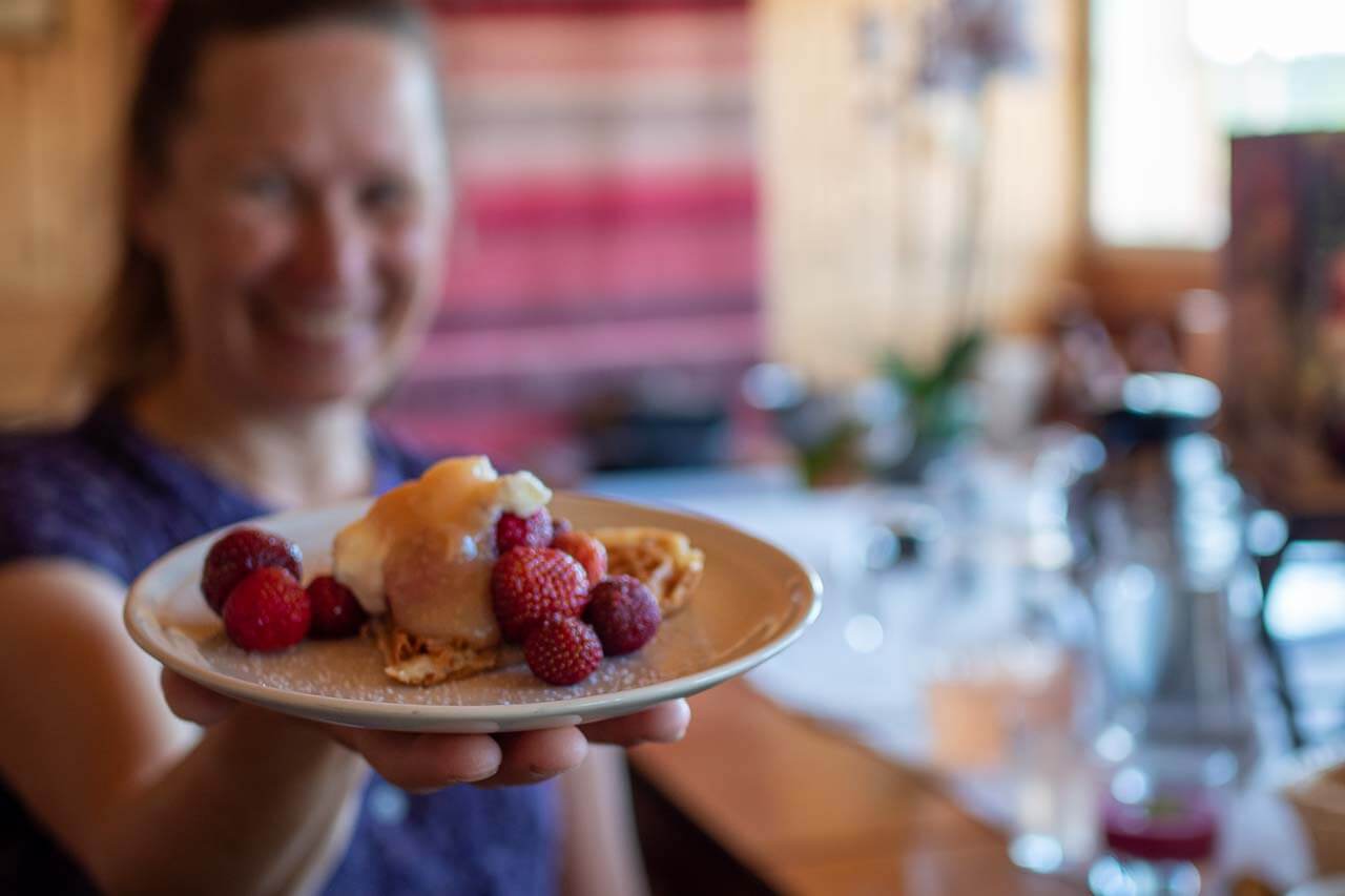 Ruokailu on osa elämystä. Saimaan pyöräkierroksella Tuukkalan tilan isäntä tarinoi aamiaispöydässä paistaen samalla vohveleita, joihin munat on kerätty pihan omasta kesäkanalasta. Kuva: Tom Toivonen.
