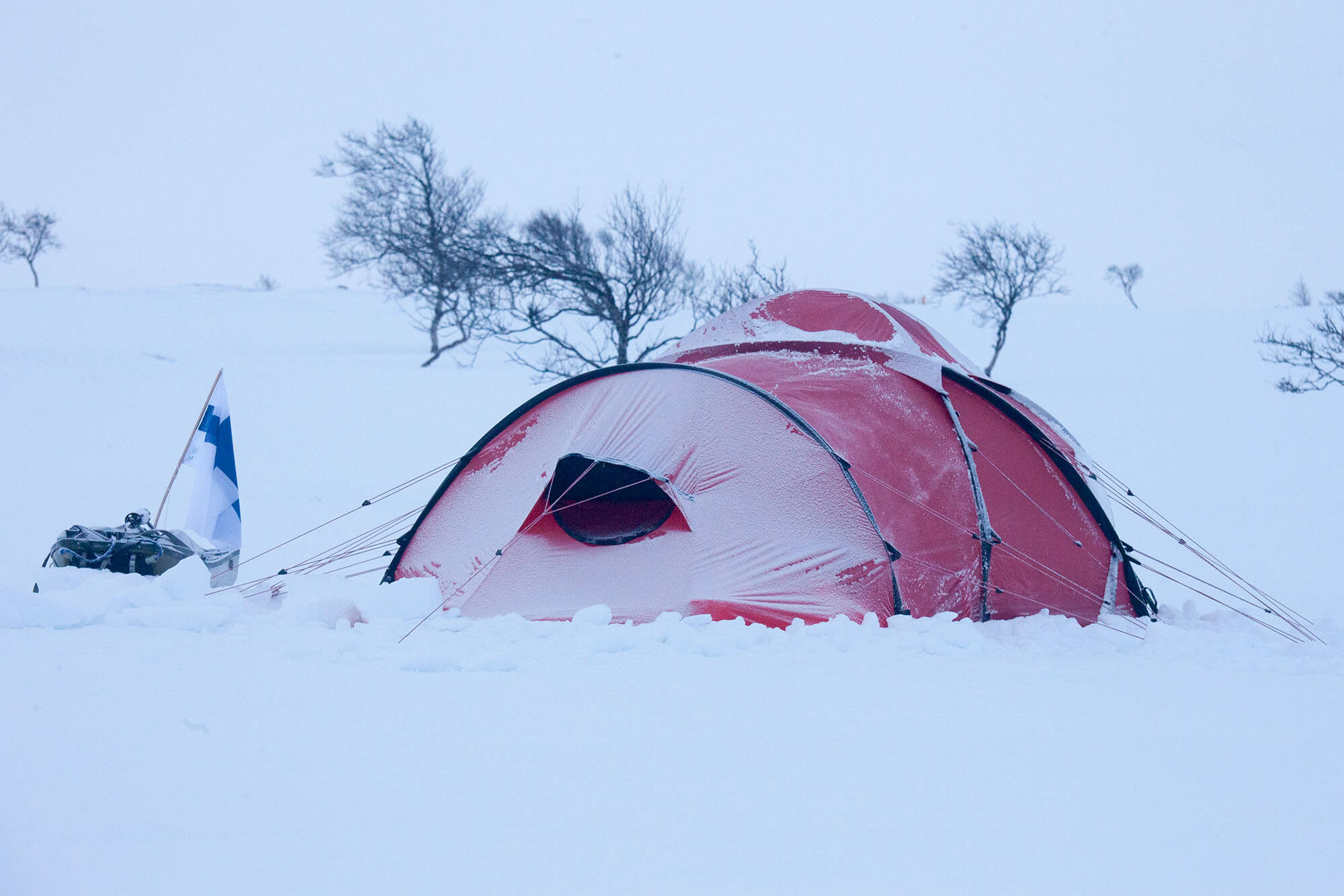Asiansa osaava kokenut talvivaeltaja pystyttää teltan kireälle ja huolellisesti aina pahimpaan varautuen. Tunturierämaassa kelit voivat muuttua ja olla keskellä yötä tai aamulla herättäessä yllättäen aivan toisenlaisia kuin illalla levolle käytäessä. Kuva: Sauli Herva.