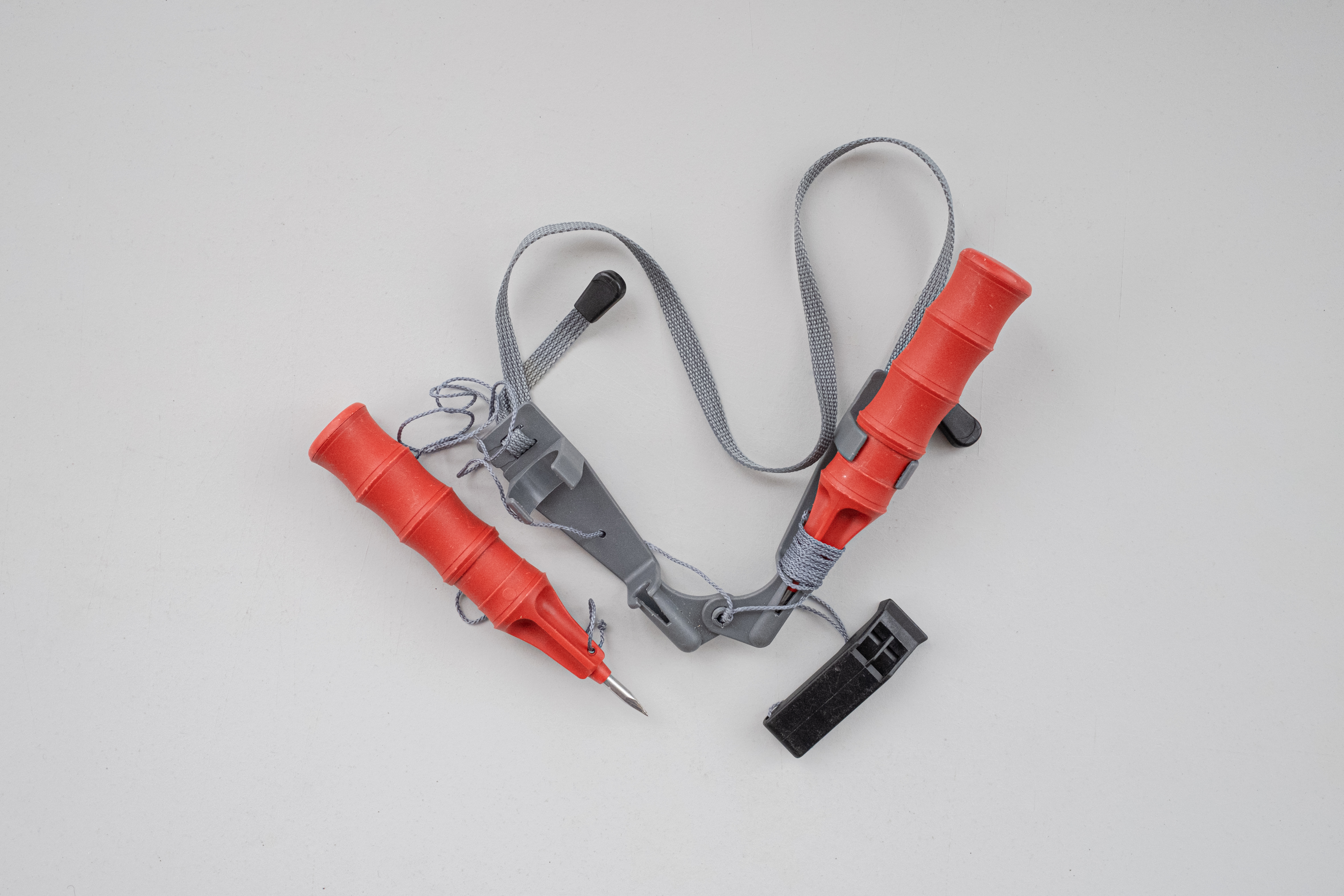 RAPALA PRO GUIDE. Tähtiluokitus: 3/5. Ripustettavista malleista Rapalan muotoilu on joukon pisimmälle mietitty. Erityistä kiitosta keräsi naskalien välissä oleva kuminauha. Simppelin narulukon ansiosta paketti on kiristettävissä ylös kaulalle. Tosipaikan tullen lanka joustaa, ja lukko antaa tarpeen mukaan periksi. Käyttöönotto vaatii molempia käsiä, mutta tapahtuu helposti ja nopeasti. Rapalan kahvamainen kädensija jakoi mielipiteitä. Sormikkaiden kanssa ote oli testin parhaimmistoa, mutta paksun rukkasen kanssa L-mallisen kahvan yläosa oli tiellä. Toisiinsa kiinnittyvissä naskaleissa terän ja kahvan väliin muodostuu 90 asteen kulma, joka vaikeuttaa pureutumista sohjon tai kohvajään läpi. Haastavissa olosuhteissa Rapalankin kohdalla esiintyi sutimista. Testin ainoa malli, joka ei kellu. Hintaluokka: 15 €,TWIN. Tähtiluokitus: 1,5/5. Kotimaiset Twin-naskalit kiristetään sopivalle korkeudelle Rapalan tapaan. Kaulalla paketti on huomattavan leveä ja häiritsee käsien liikettä ainakin hiihdossa. Tilanteen vaatiessa naskalit löytyivät käsille ja irtosivat toisistaan helposti. Heppoiseksi osoittautunut liukulukko vapautti narun moitteettomasti, mutta murtui testipäivän aikana. Litteän kahvan tarjoama ote ei ole paras mahdollinen. Kahvan alaosassa oleva levennys paransi otetta, mutta lisää olennaisesti piikkiä vasten muodostuvaa kulmaa. Piikki itsessään puree jäähän hyvin. Hintaluokka: 12 €,FISHERMAN. Tähtiluokitus: 1/5. Testin edullisimmat naskalit ovat ainoat, joista ei löydy minkäänlaista kiristystä. Fishermanit roikkuvat leveän kuminauhansa varassa vapaasti suurin piirtein navan korkeudella. Kävellessä ne ovat korkeintaan häiriöksi, mutta veden varassa ongelmana on etenkin tiukka kiinnitys. Vähänkään väärässä kulmassa naskaleita on vaikea saada irti toisistaan. Tässäkin mallissa näkyvä terä päättyy 90 asteen kulmassa olevaan kahvaan. Kädensija on lyhyt ja kapea. Kovaa sai lyödä, mutta näilläkin tultiin ylös. Hintaluokka: 5 €,Kaulatelineessä naskalit kulkevat mukana huomaamattomasti ja ovat tarpeen tullen saatavilla.