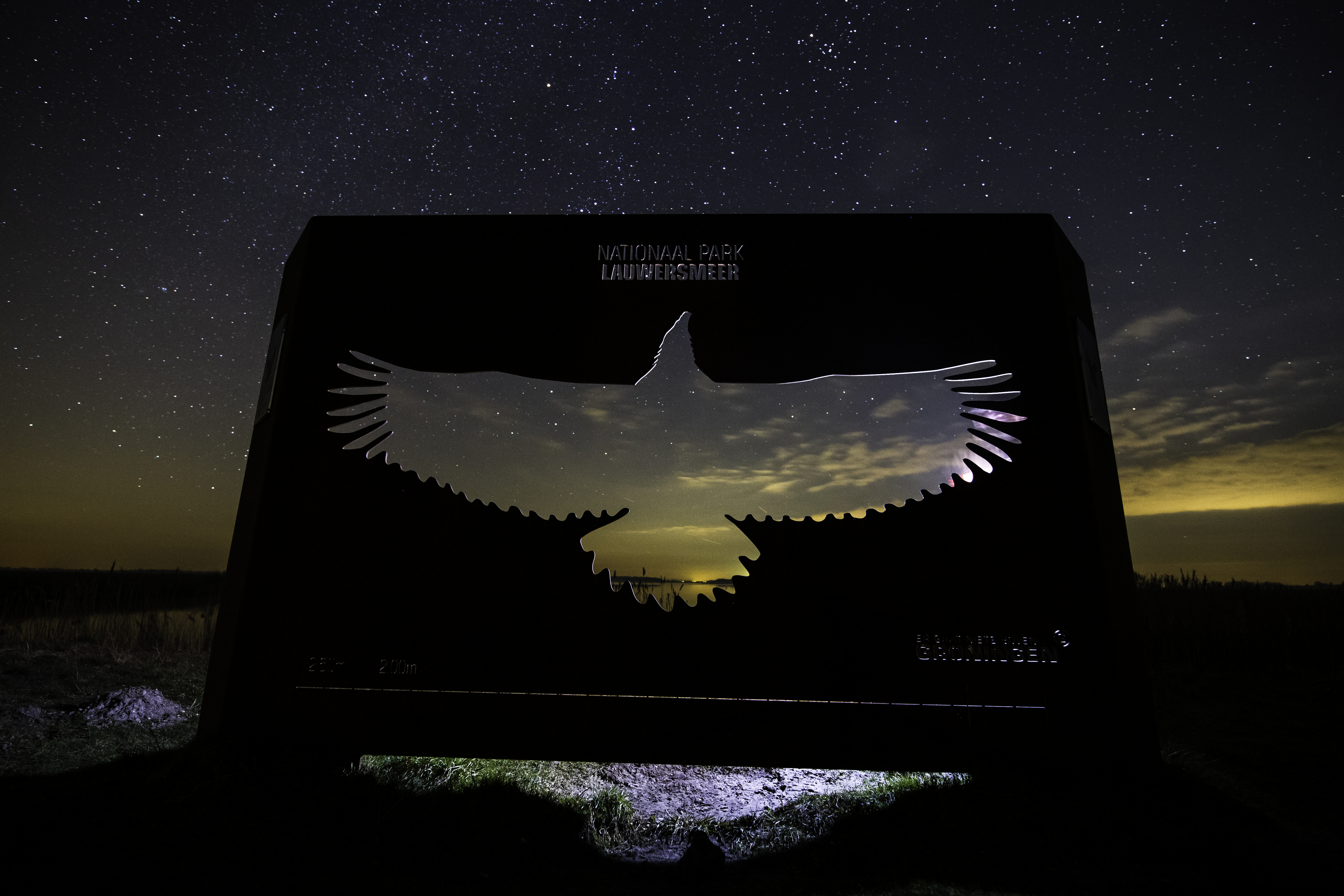 Lauwersmeerin kansallispuiston tunnus yötaivasta vasten